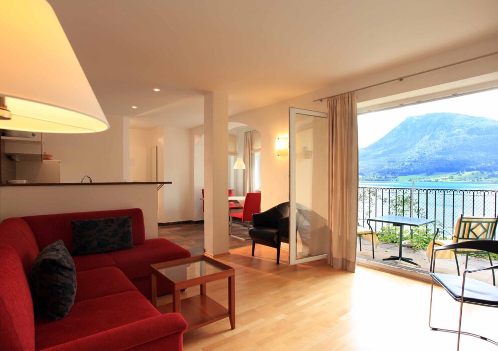 Wohnzimmer in der Ferienwohnung Belvedere mit Blick auf den Balkon und dem Wolfgangsee