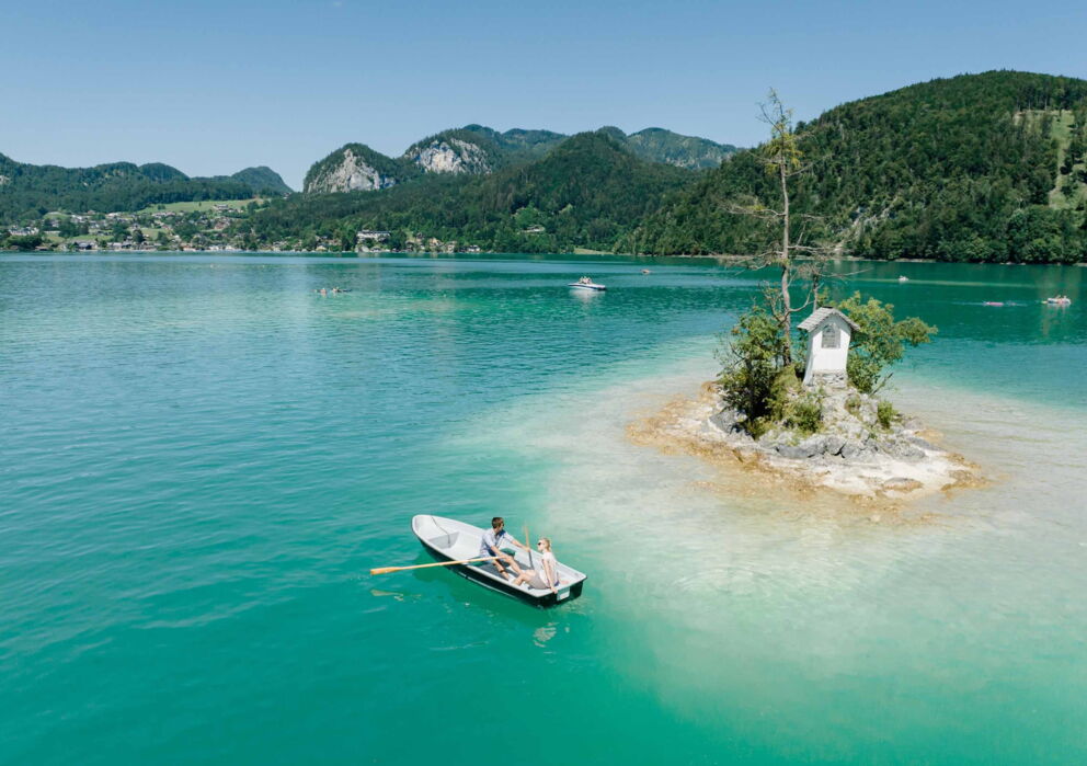 Couple on a rowing trip amidst the turquoise-blue Wolfgangsee lake