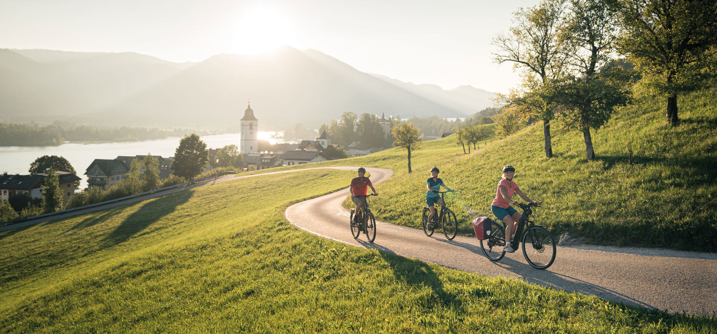 Three cyclists on a road in Sankt Wolfgang