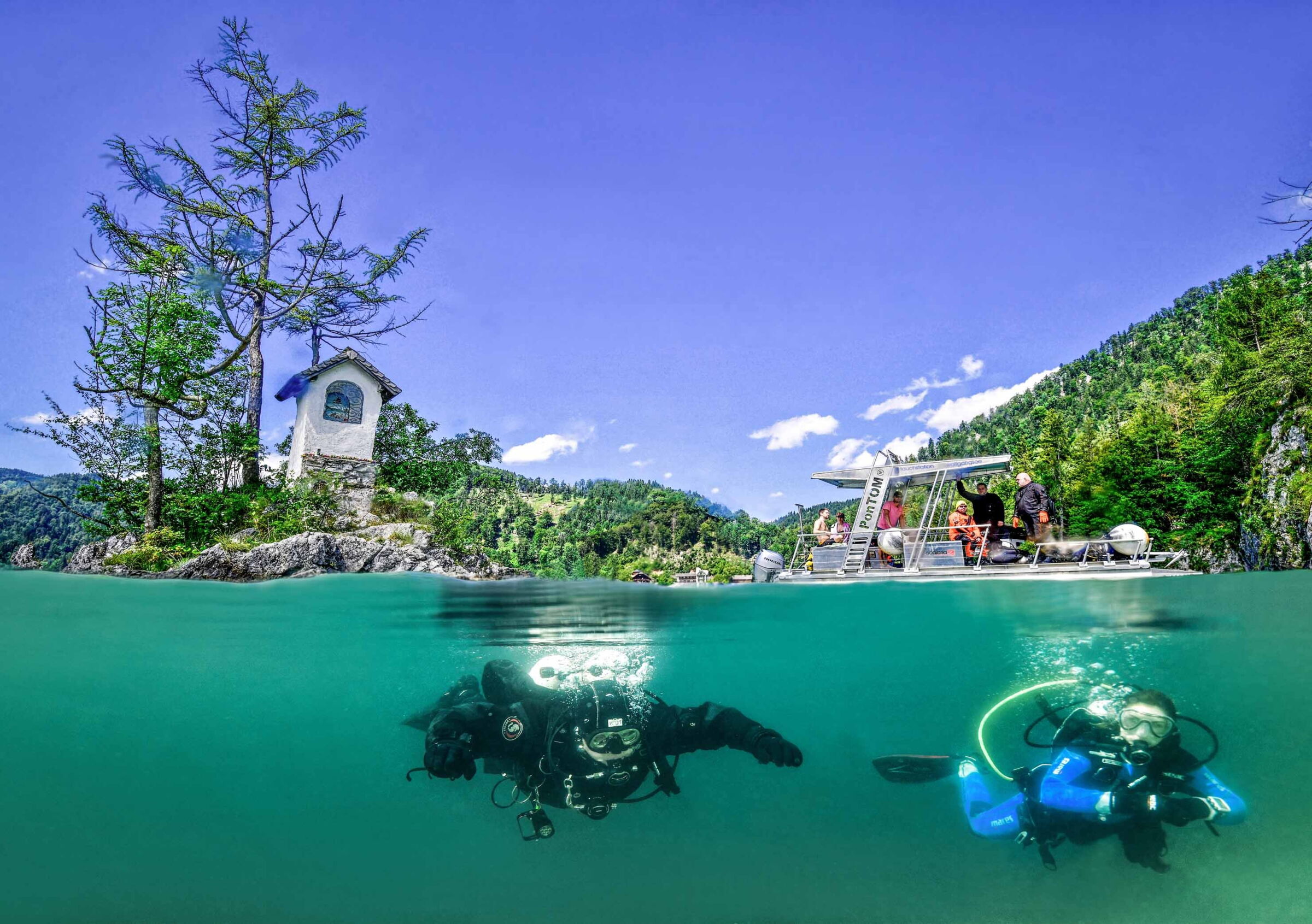 Zwei Taucher im kristallblauen Wasser des Wolfgangsees