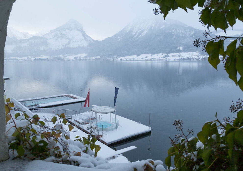 Sicht auf den verschneiten Rösslpool und auf das Seebad in winterlicher Landschaft