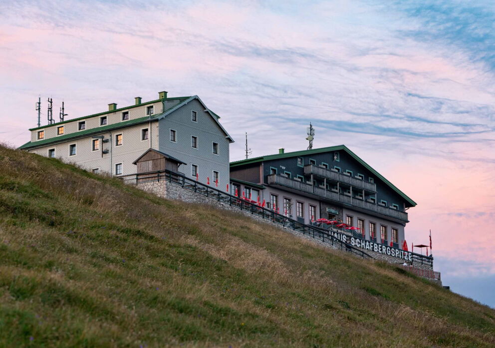 Sicht von der Wieso aus auf das Schafbergspitze Haus und den im Abendschein glühenden Himmel