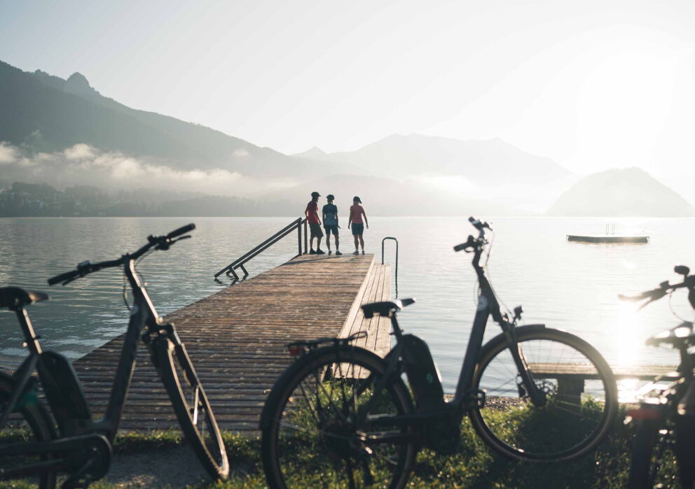 Eine befreundete Gruppe Radfahrer beim Pause machen an einem Steg am Wolfgangsee
