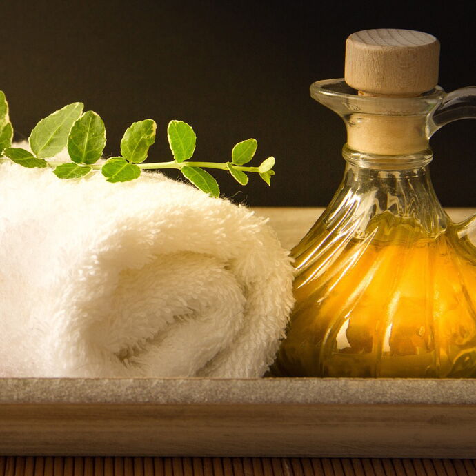 Weisses Handtuch mit einem Krug Aromaöl