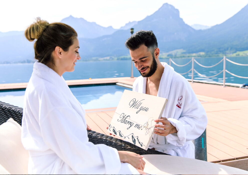Ein Mann der seiner Freundin am Wolfgangsee im Hotel Im Weissen Rössl einen Heiratsantrag macht.