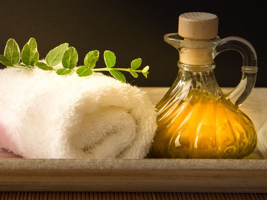 Weisses Handtuch mit einem Krug Aromaöl