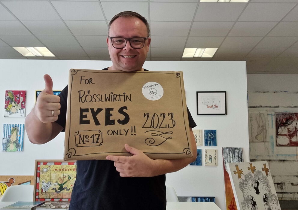 Mann mit einem Paket mit der Aufschrift ,,For Rösslwirtin Eyes Only''