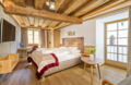 Gemütliches Doppelzimmer mit warmem Holz, sichtbaren Deckenbalken und komfortablem Doppelbett. Ein behaglicher Rückzugsort für entspannte Tage im Romantik Hotel Im Weissen Rössl am Wolfgangsee.