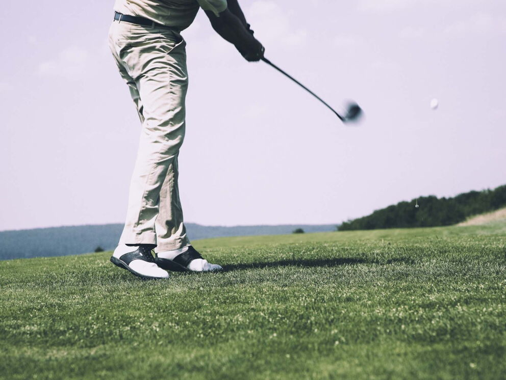 Ein man schlägt einen Golfball