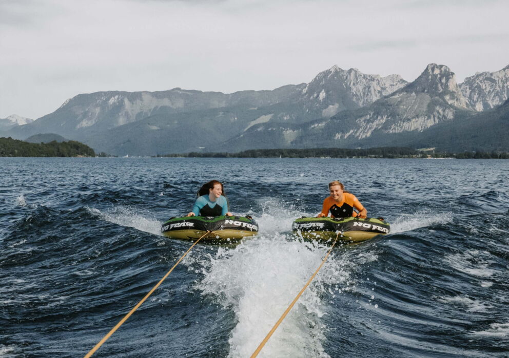 Two friends tubing at the Wolfgangsee in Austria in the Salzkammergut region