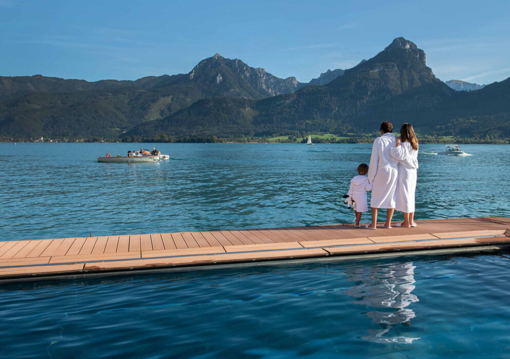 Kleine Familie auf dem Seebad im Wolfgangsee mit Bademantel