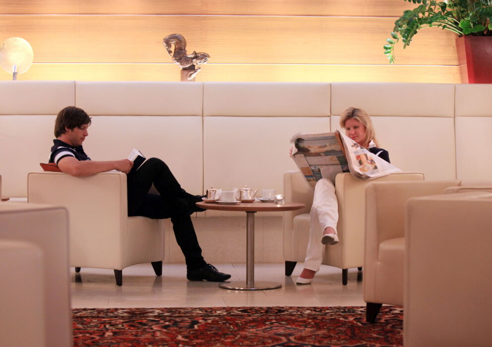 Eine Frau und ein Mann sitzen an einem Kaffee Tisch und lesen