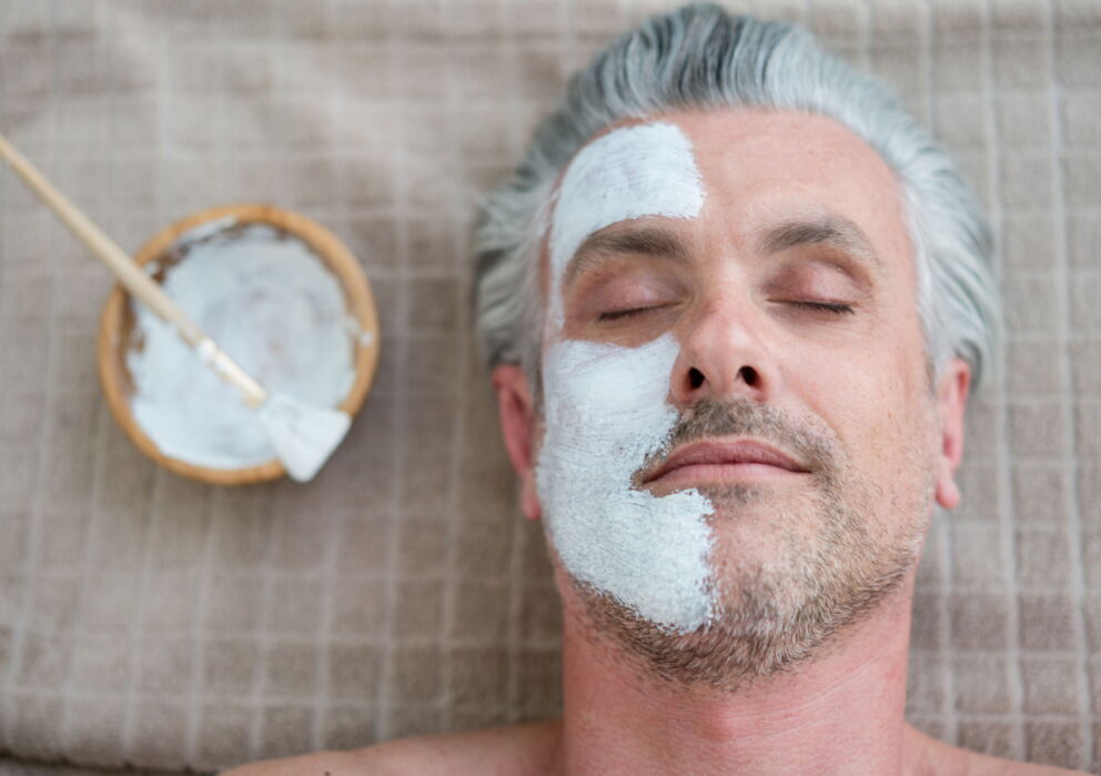 Mann mit Peeling im Gesicht das aber nur auf einer Hälfte des Gesichtes aufgetragen wurde