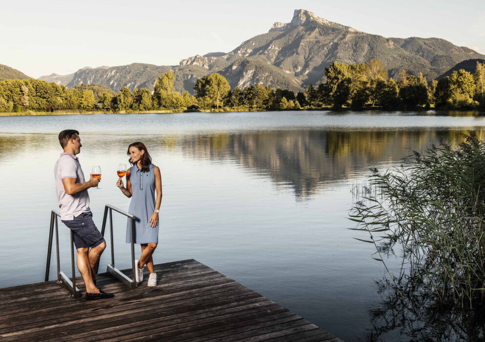 Ein Pärchen am Wein trinken am Drachensee des Golfclubs am Mondsee