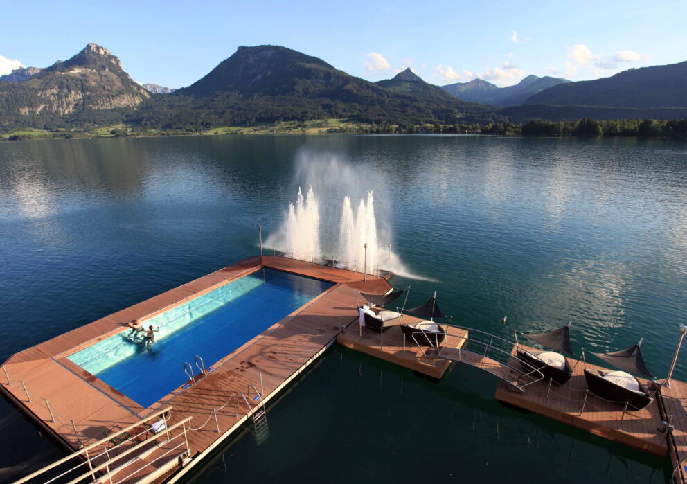 zwei Personen im beheizten Seebad vor der wasser Fontäne des Hotels Im Weissen Rössl