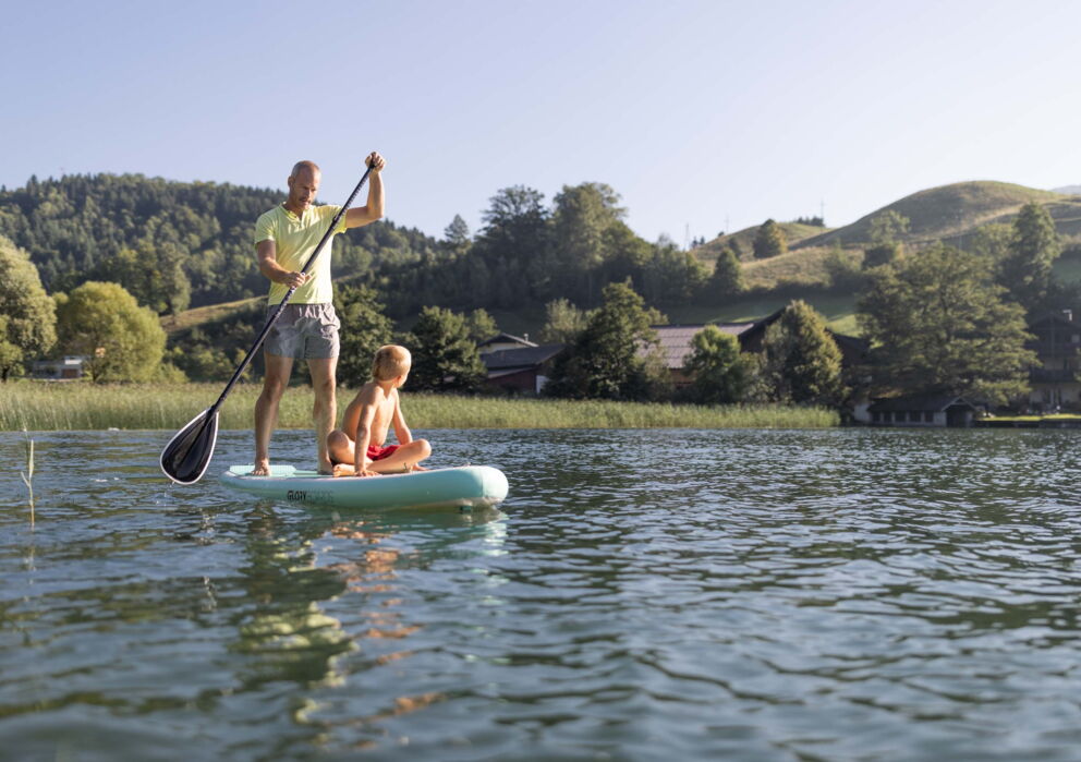 Vater mit seinem Sohn beim Stand up Paddling am Wolfgangsee