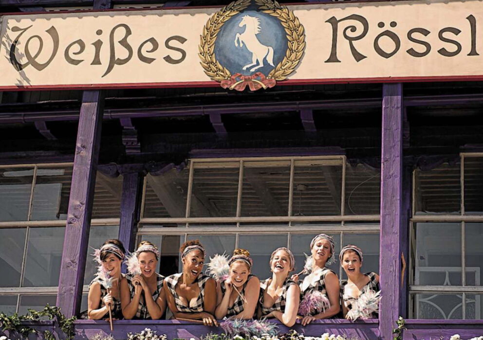 Die Putzfrauen erwarten die Gäste auf dem violetten Balkon des Weißen Rössls in der 2013 erschienenen Neuauflage des Klassikers ''Das Weisse Rössl am Wolfgangsee'' Film aus 1952