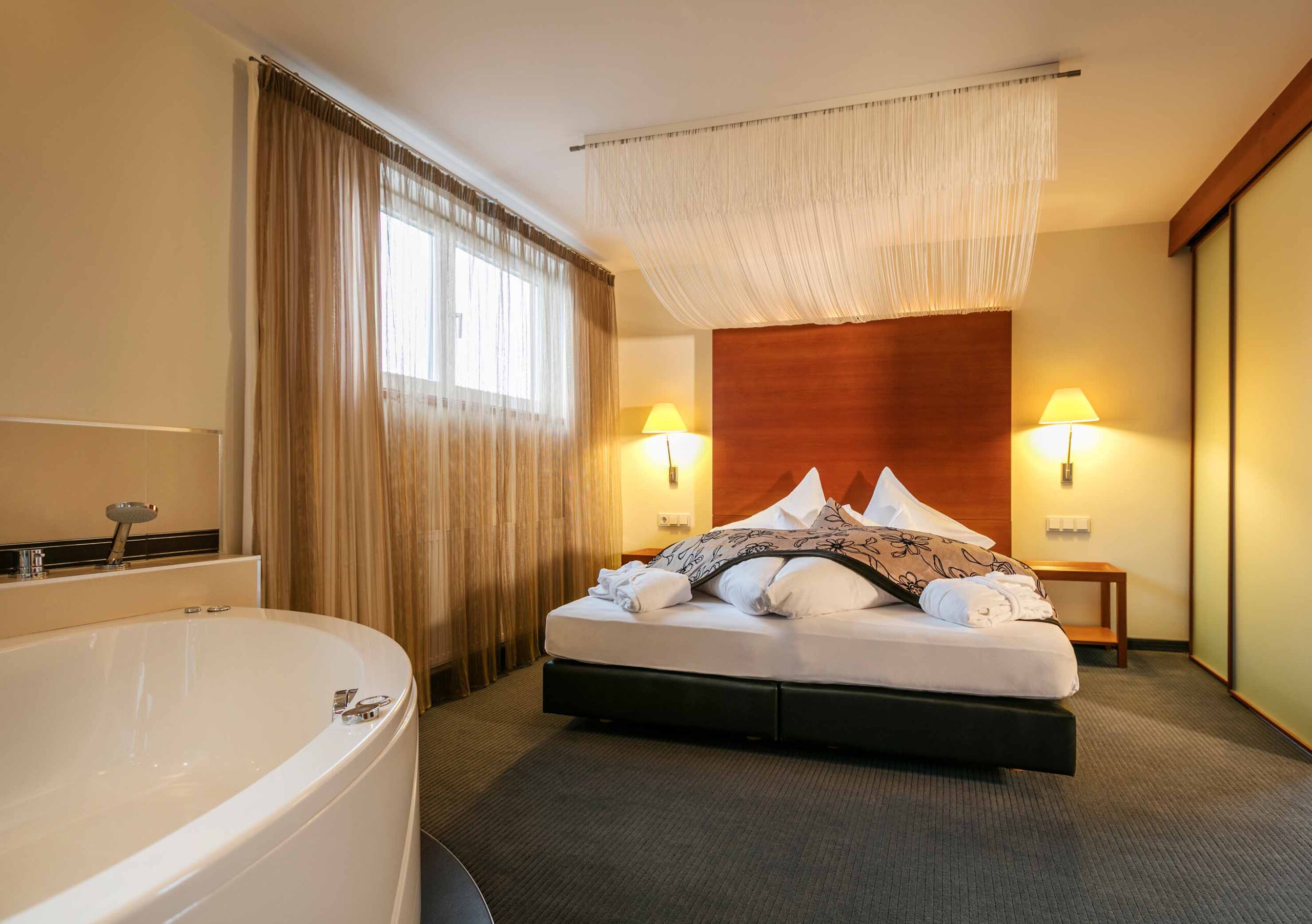 Geräumiges Schlafzimmer im Weissen Rössl am Wolfgangsee mit freier offenen Badewanne im modernen Stil eingerichtet
