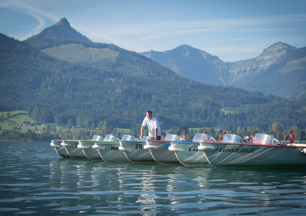 Ein Mann auf einem von vielen ausleihbaren Booten am Wolfgangsee im Salzkammergut