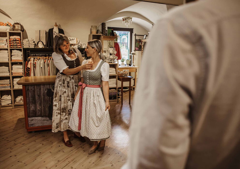 Zwei Frauen mit traditionellem Dirndl Gewand in einem Trachten Geschäft