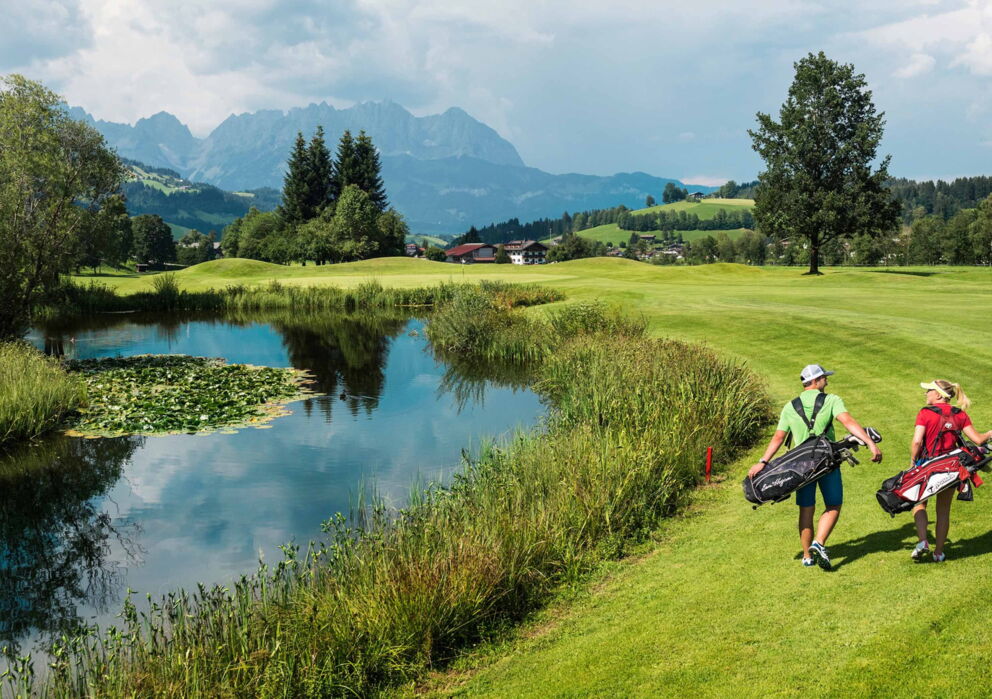 Zwei Golfer am Golfgelände mit atemberaubender Berglandschaft