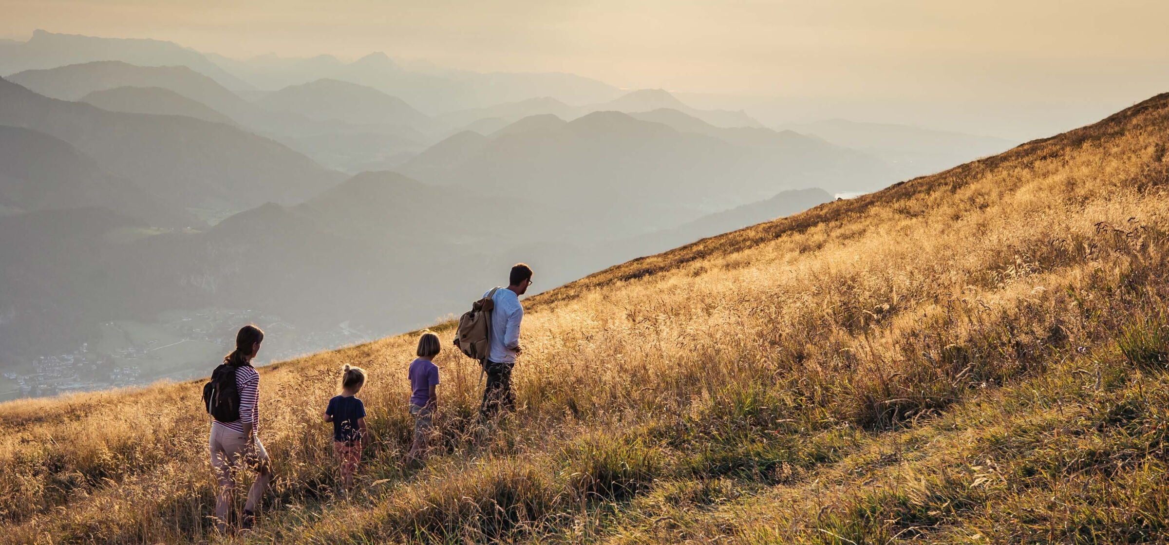 Eine Familie wandert über eine Wiese