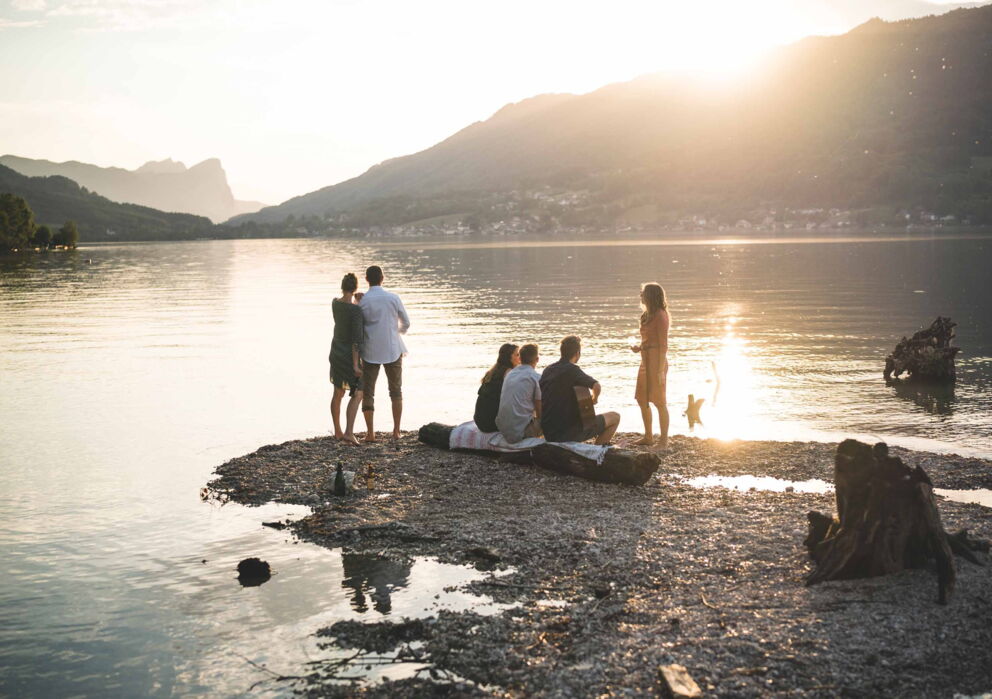 Group of friends on the shore of Lake Wolfgang at sunset