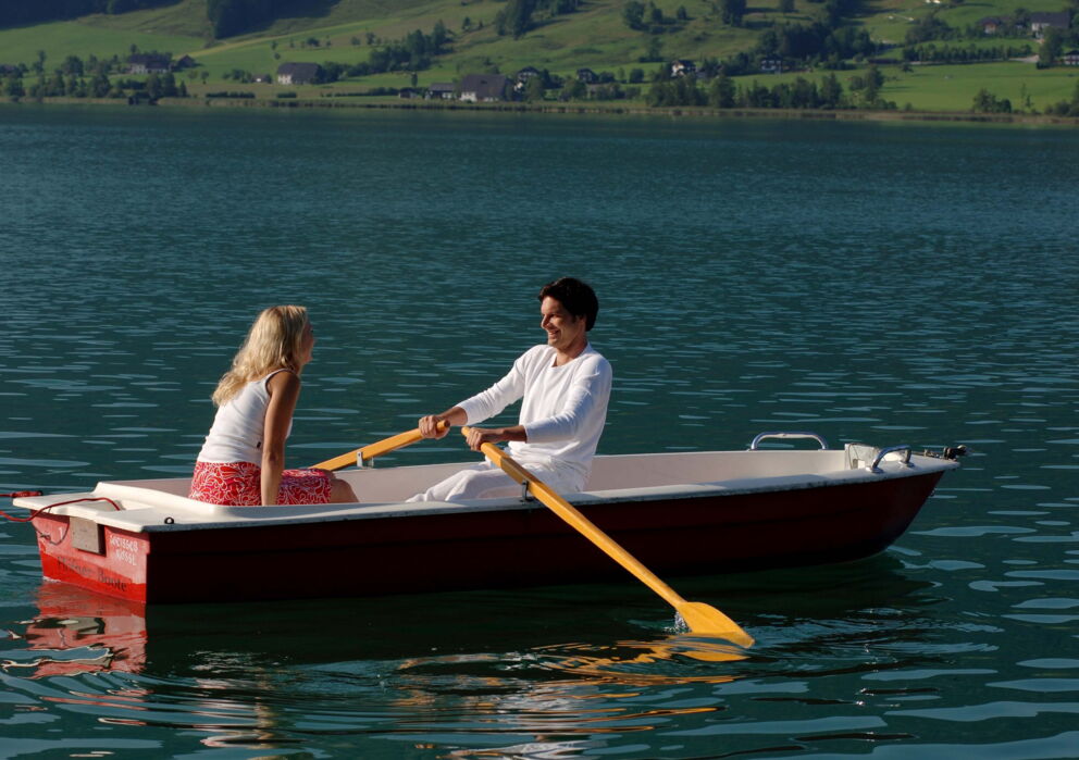 Eine Frau und ein Mann sitzen in einem Ruder boot