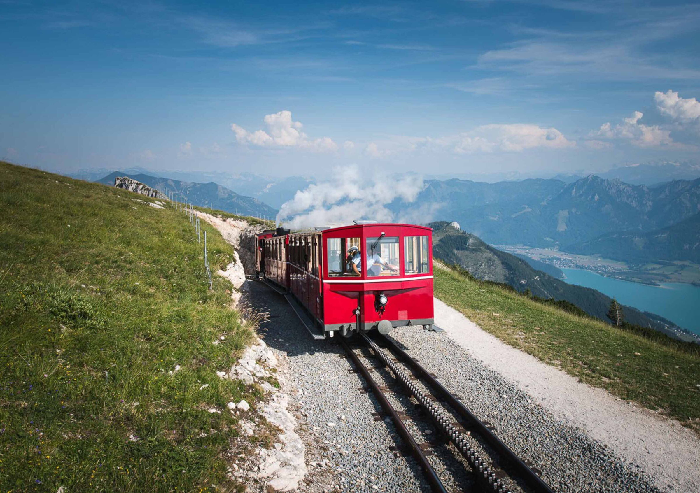 Frontansicht der fahrenden Schafbergbahn mit dem Blick auf den Wolfgangsee
