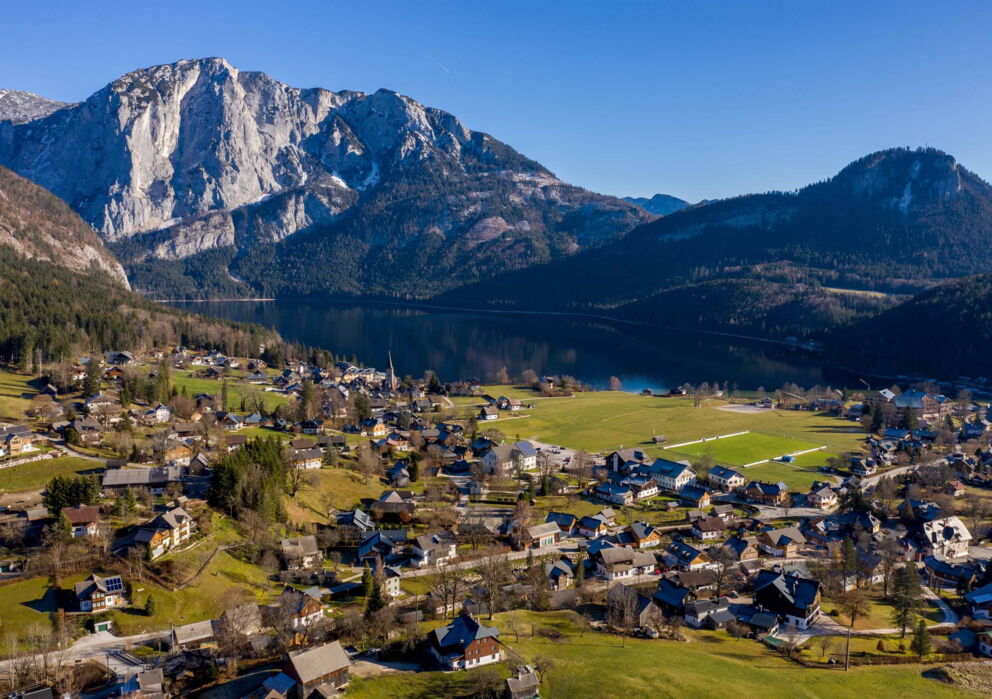 Blick auf ein kleines Dorf mit einem See und einer wunderschönen umliegenden Berglandschaft