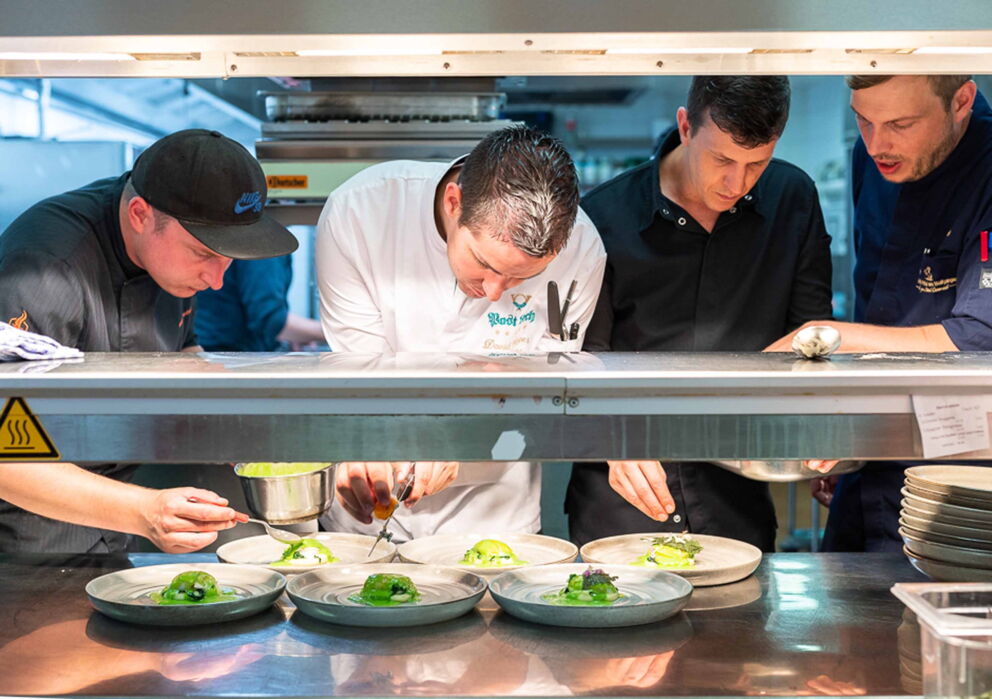 Group of chefs preparing a culinary delicacy.