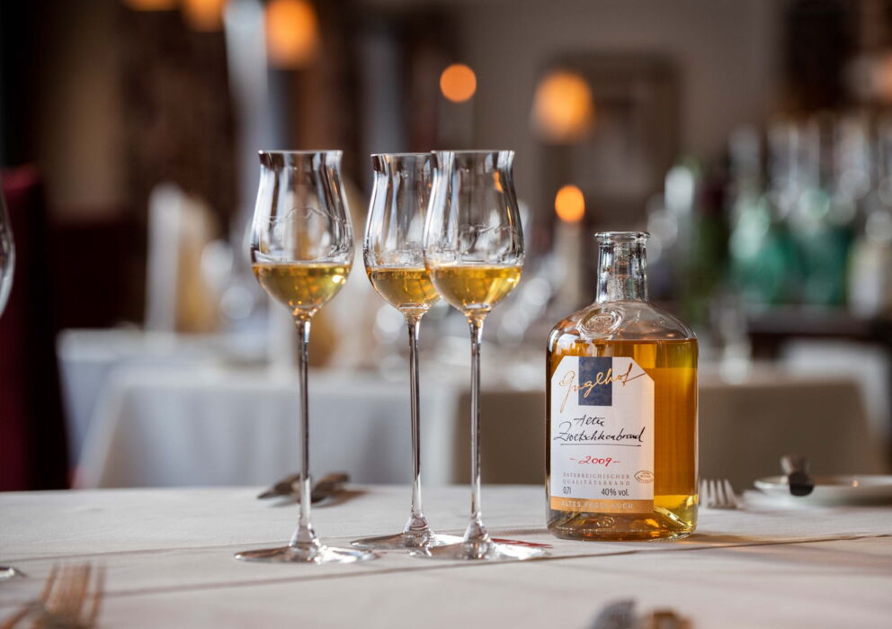 Three glasses with plum digestif on a set table