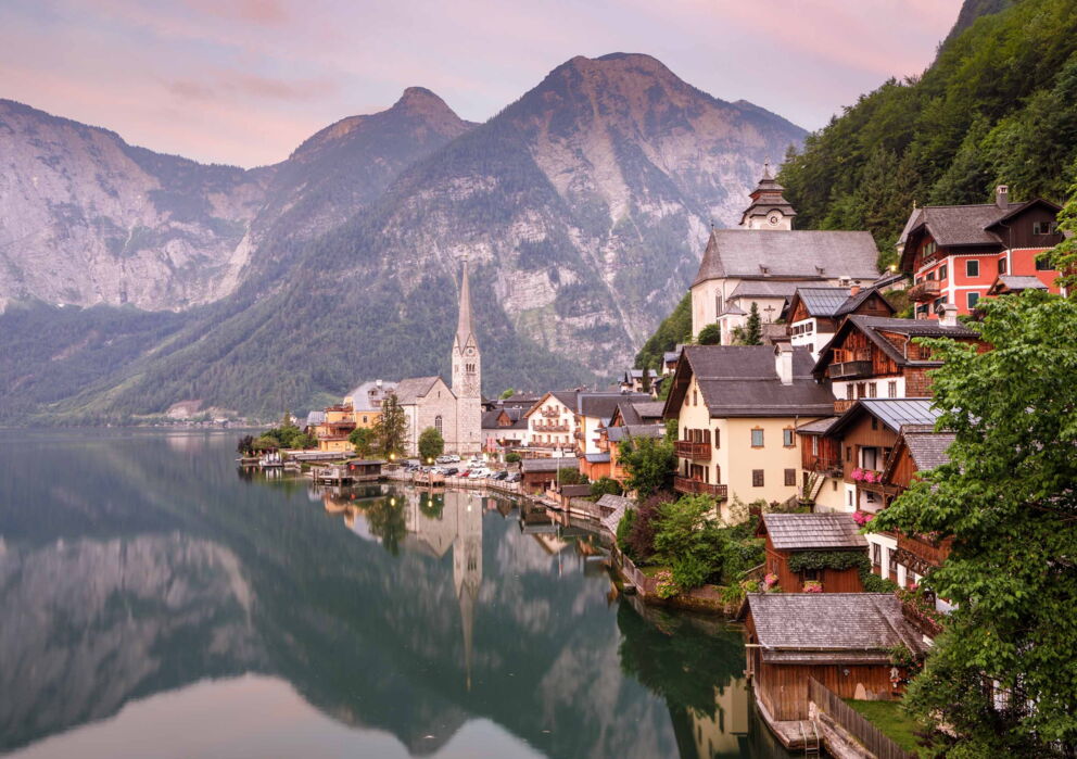 Das Weltkulturerbe Hallstatt in Österreich und die umliegende schimmernde Berglandschaft im Abendgrauen