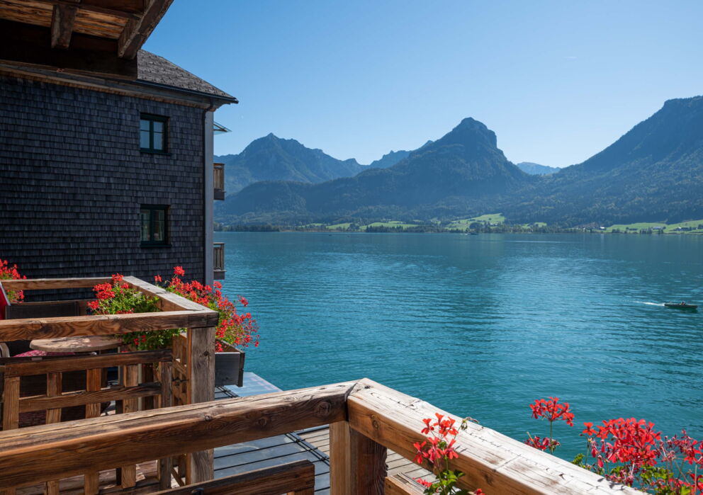 Sicht vom Balkon auf den türkis schimmernden Wolfgangsee und den umliegenden Bergen