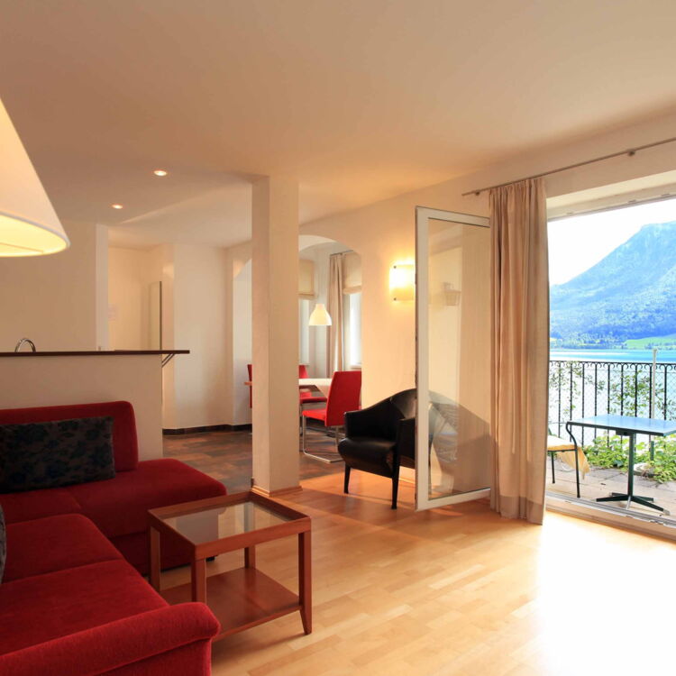 Wohnzimmer in der Ferienwohnung Belvedere mit Blick auf den Balkon und dem Wolfgangsee