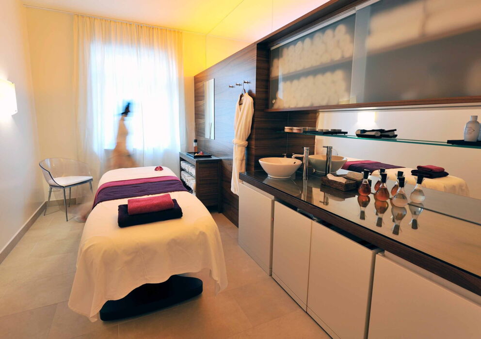 Massage Liege in einem Raum mit Handtüchern und verschiedenen Massageölen