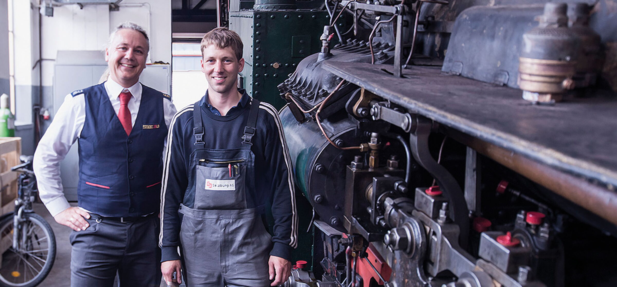 Ein Techniker und ein Schaffner der Salzburg AG stehen neben der Scharfberg Bahn
