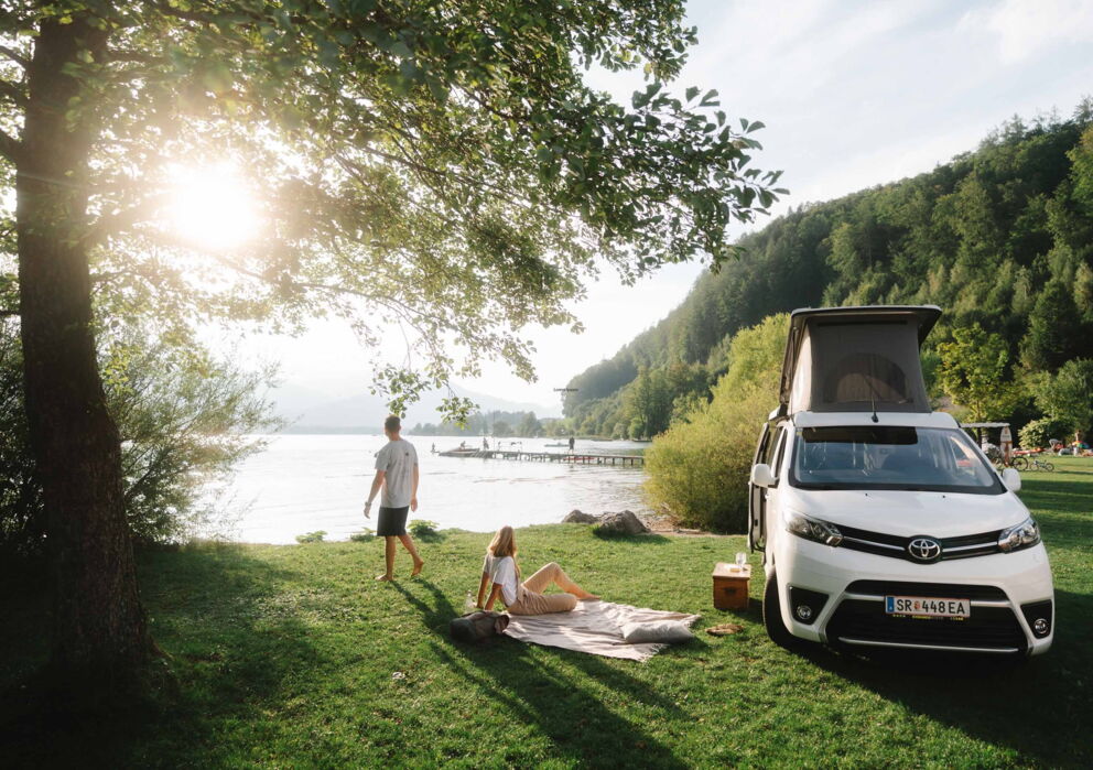 A man and a woman with a caravan at the lake