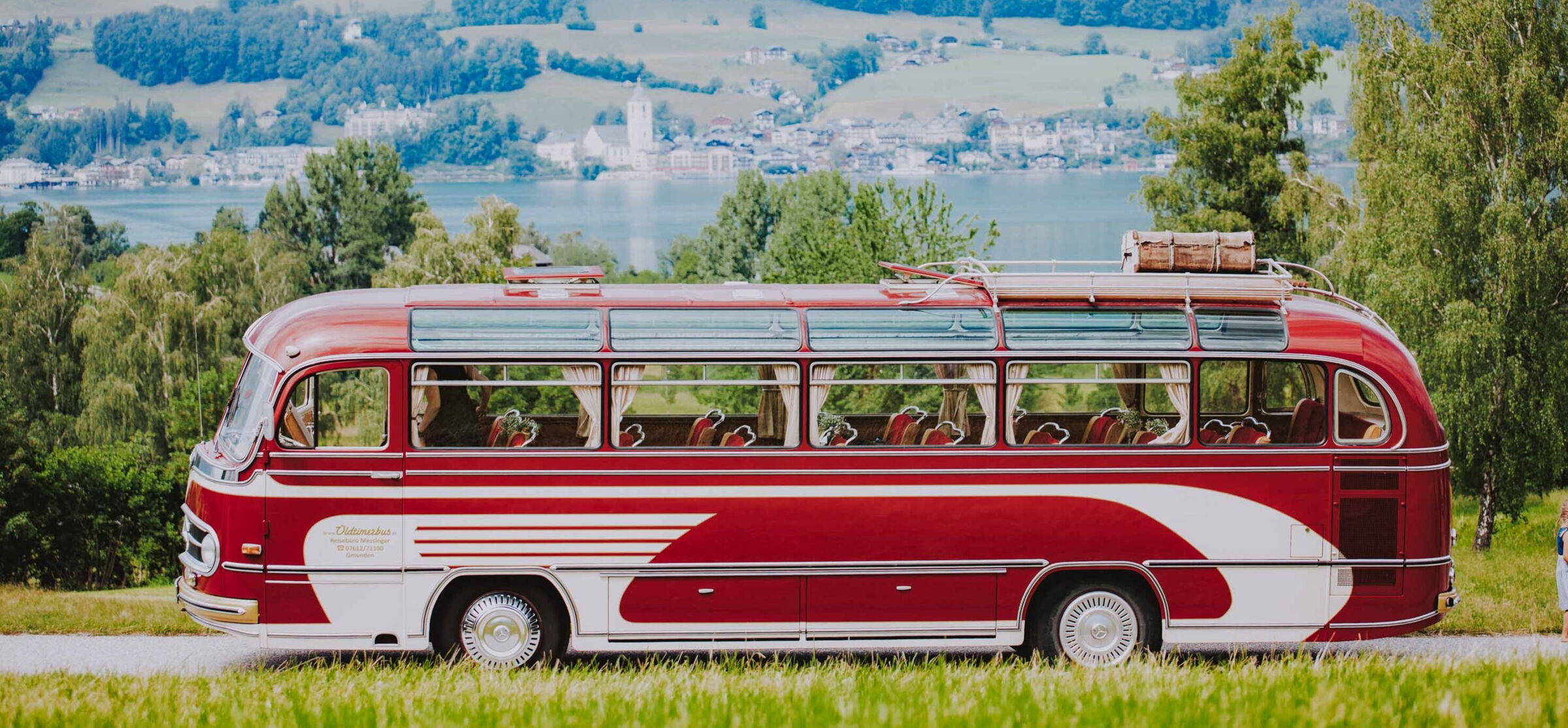 A vintage bus drives on a panoramic road in the Salzkammergut region