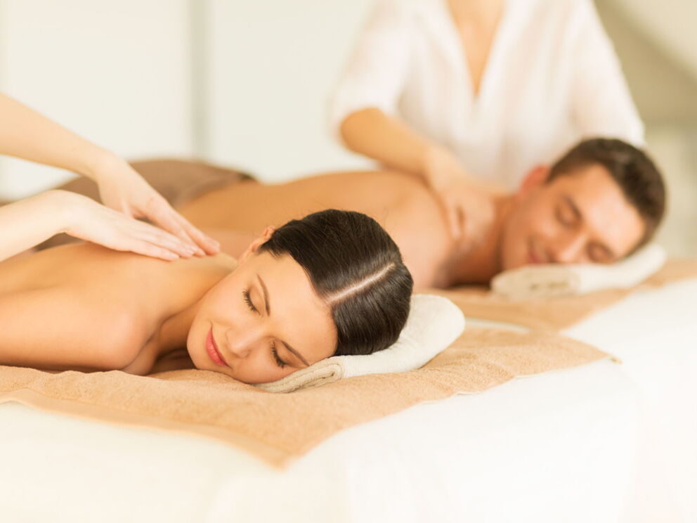A couple is massaged next to each other.