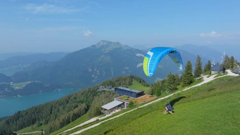 Man sieht wie zwei Paragleiter den Hügel zum Start hinunter laufen. ©Flugschule Salzkammergut