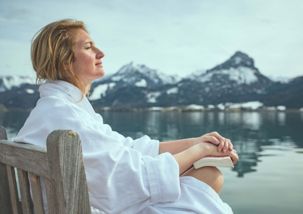 Entspannende Frau mit einem Buch im winterlichen Sankt Wolfgang am Wolfgangsee