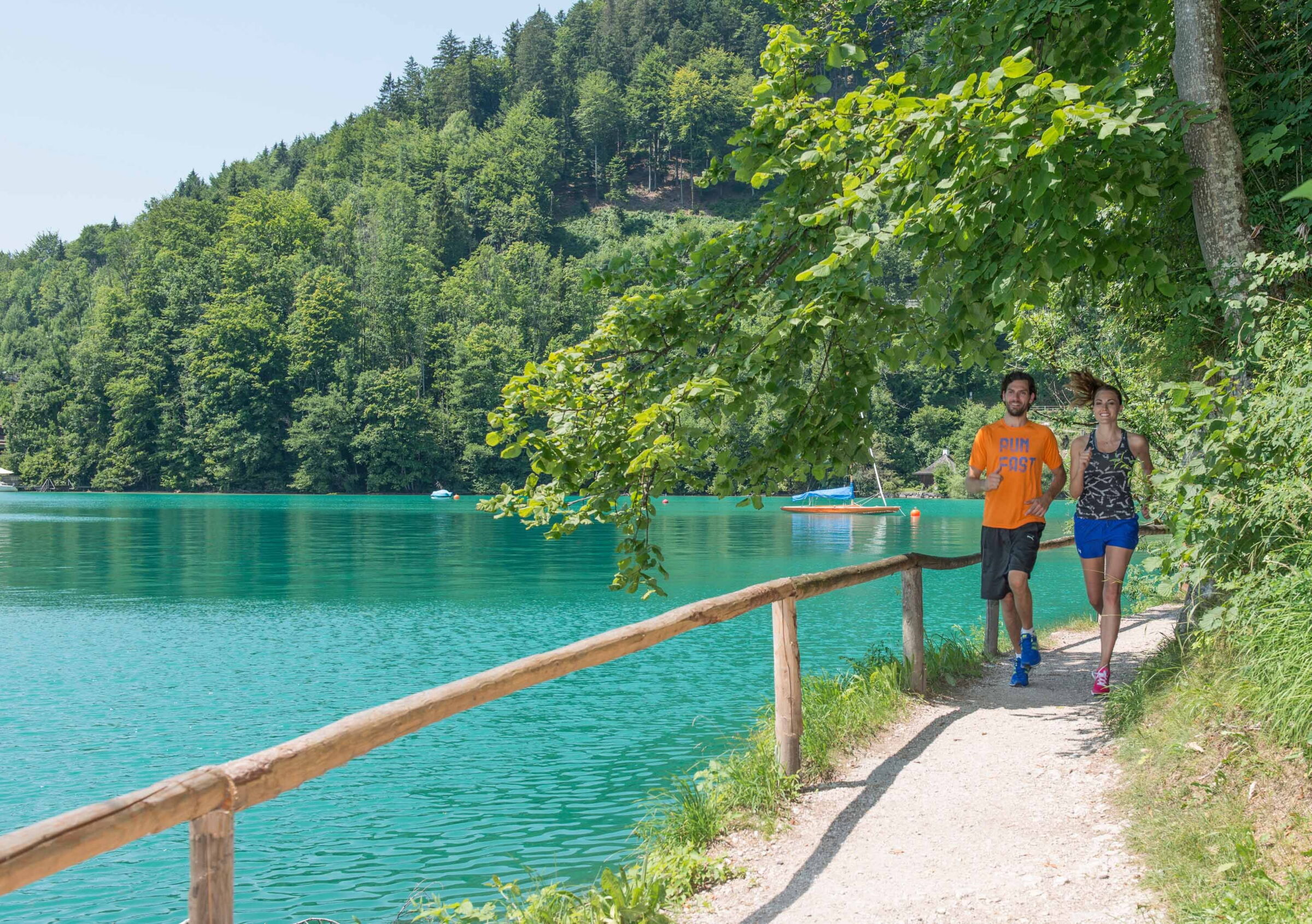 Zwei menschen laufen an einem See entlang