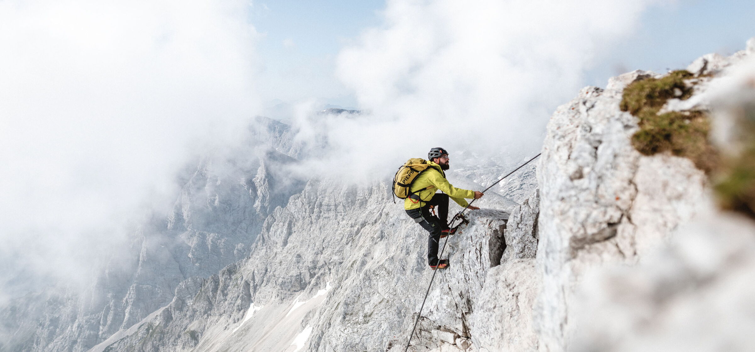 Mann am Erklimmen eines Gipfels im tiefen Salzkammergut
