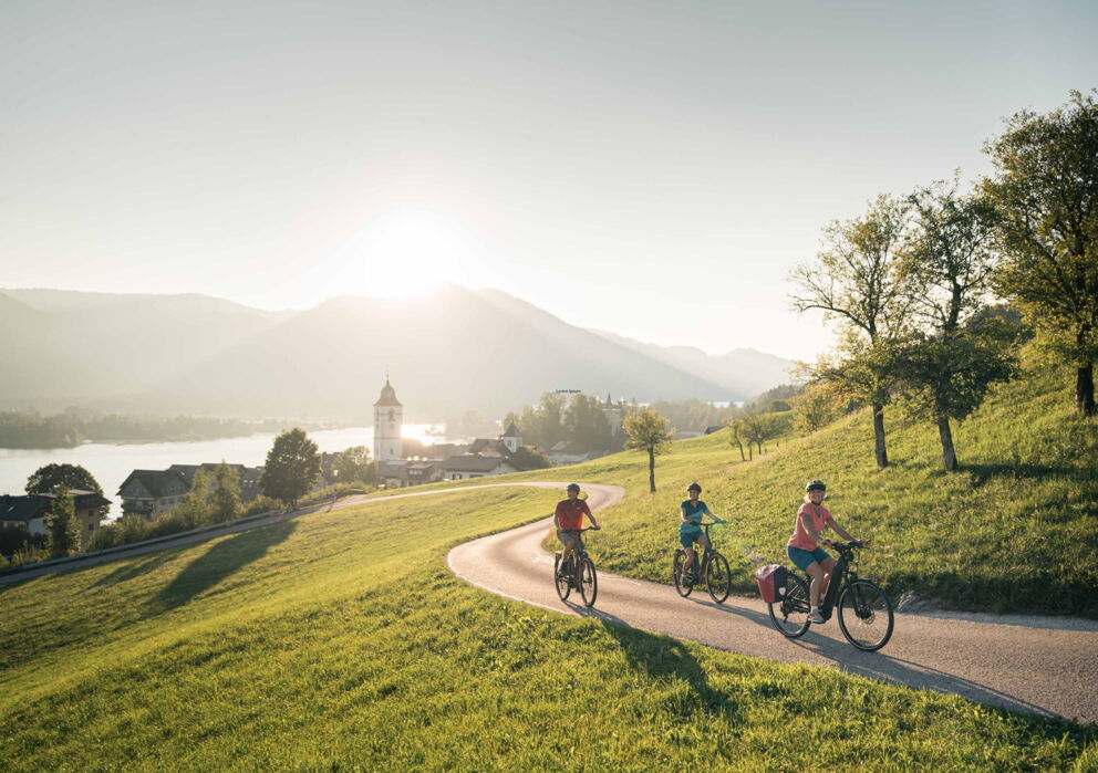 Three cyclists on a road in Sankt Wolfgang