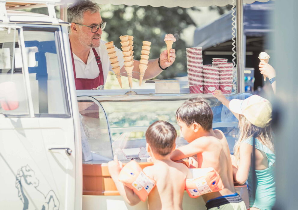 Verkäufer der Rössl Eis Manufaktur verkauft Eis an Kinder