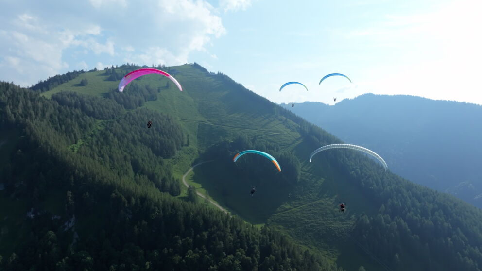 Mehrere Paragleiterfliegen fliegen über das Zwölferhorn. ©Flugschule Salzkammergut